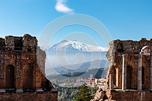 Taormina - Panoramic view of snow capped Mount Etna volcano seen from the ancient Greek theatre of Taormina, island Sicily, Italy