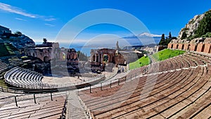 Taormina - Panoramic view of snow capped Mount Etna volcano seen from the ancient Greek theatre of Taormina, island Sicily, Italy