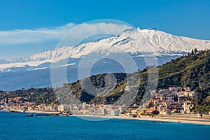 Taormina shore at Ionian sea with Giardini Naxos town and Mount Etna volcano in Messina region of Sicily in Italy