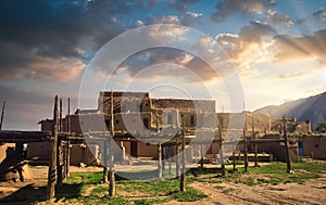 Taos Pueblo Illuminated by the Morning Sun over the Sangre de Cristo Mountains in New Mexico photo