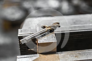 A tap on a machine for tapping a hole in a part