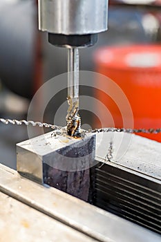 A tap on a machine for tapping a hole in a part