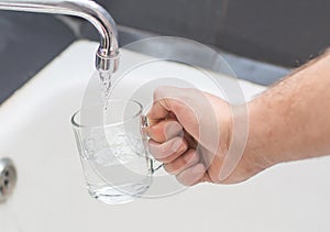 Tap water is poured into a glass cup