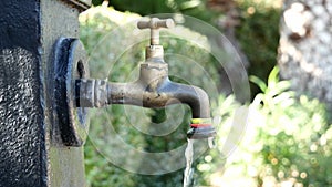 Tap water pouring from faucet outdoors