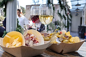 Tapas bar. Cheese, ham and pinchos with peppers, with glasses of red and white wine