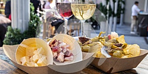 Tapas bar panorama. Cheese, ham and pinchos with red and white wine on a wooden table