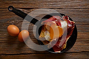 Tapas huevos rotos broken eggs with ham photo