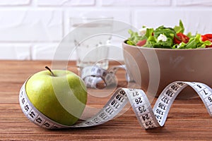 tape and lettuce on a light background. Slimming, diet, healthy food.