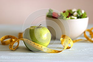 tape and lettuce on a light background. Slimming, diet, healthy food.