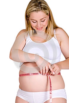 Tape-meassuring my pregnant belly while smiling