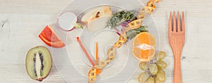 Tape measue with fruits and vegetables in shape of clock showing time to healthy eating and slimming