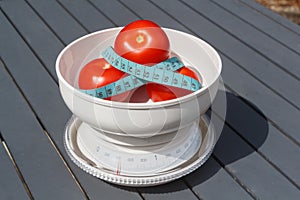 Tape measure around tomatoes on a scales