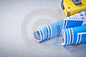 Tape-measure blue engineering drawings on grey background constr