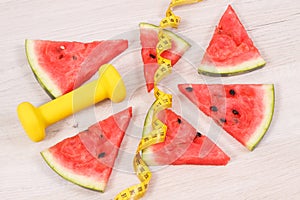 Tape measure, dumbbells and watermelon containing minerals, healthy nutrition, lifestyles and slimming concept