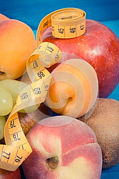 Tape measure with fresh natural fruits containing nutritious vitamins for healthy lifestyles