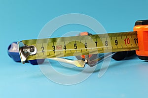 A tape measure with screwdrivers, cross-point screwdriver. Measure show us ten centimetre