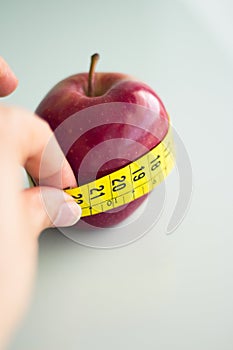 Tape measure surrounding a red apple