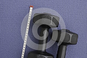 Tape measure and weights, concept of being fit and exercising on a yoga mat photo