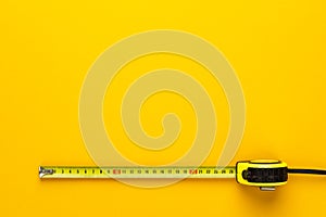 Tape measure on the yellow background