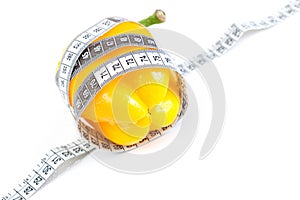 Tape measure and yellow pepper isolated on white