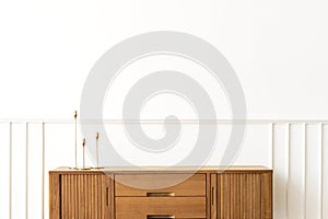 Taper candle holders on a wooden sideboard table photo