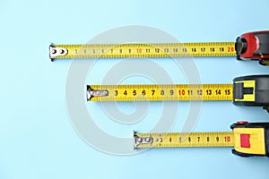 Tapes measure on light blue background, flat lay. Construction tool