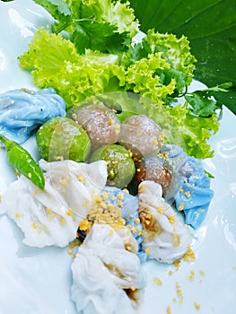 Tapioca dumplings with lettuce and bird pepper on white plate