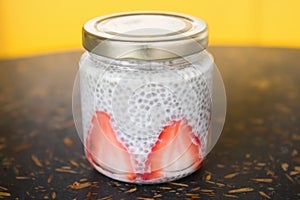 Tapioca jar with strawberries on yellow background. Dessert jar with strawberries. Concept grab and go