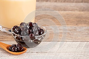 Tapioca Pearl , Bubble topping for tea or other beverage, in a cup, place on wooden table. Copy space