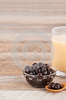 Tapioca Pearl , Bubble topping for tea or other beverage, in a cup, place on wooden table. Copy space