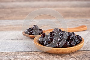 Tapioca Pearl , Bubble topping for tea or other beverage, in a cup, place on wooden table. Copy space