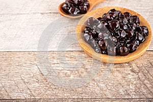 Tapioca Pearl , Bubble topping for tea or other beverage, in a cup, place on wooden table. Copy space