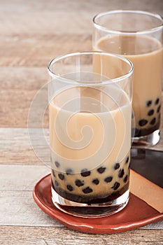 Tapioca Pearl , Bubble topping for tea or other beverage, in a cup, place on wooden table. Copy space