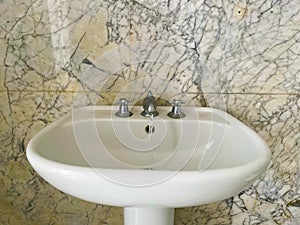 taps mounted on a marble tile bottom sink