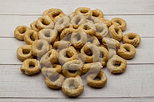 Taralli alla pugliese with extra virgin olive oil on wooden background. Traditional italian snack Taralli