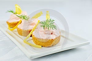 Taramasalata canape, fish-roe spread bites with lemon slices over bread