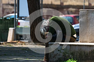 Taranto, Apulia / Italy - 03/23/2019 : A lost homeless old man depressed on bench