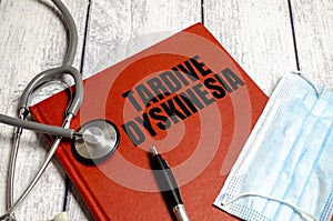 Tardive Dyskinesia - Diagnosis written on red diary with stethoscope