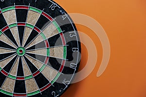 Target dart board on the table with orange background, center point, head to target marketing and business success concept