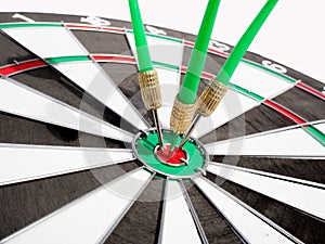 Target with three green dart focus on bull`s eye, Setting challenging business goals And ready to achieve the goal with teamwork