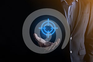 Targeting concept with businessman hand holding target icon dartboard sketch on chalkboard. Objective target and investment goal
