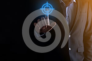 Targeting concept with businessman hand holding target icon dartboard sketch on chalkboard. Objective target and investment goal