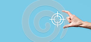 Targeting concept with hand holding target icon dartboard sketch on chalkboard. Objective target and investment goal concept