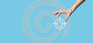 Targeting concept with hand holding target icon dartboard sketch on chalkboard. Objective target and investment goal concept