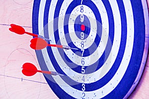 Targets for archery on a green background. Three red darts in the target.