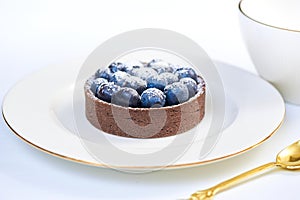 Tarlets dessert from pistachio and chocolaty bakery dough with blueberry decoration photo