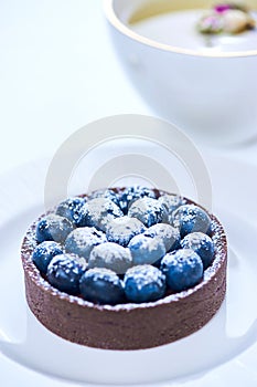 Tarlets dessert from pistachio and chocolaty bakery dough with blueberry decoration photo