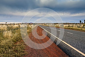 Tarmac road lead to nowhere in Australian desert in stormy cloud