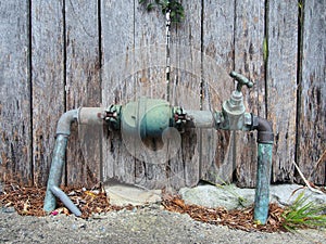 Tarnished Copper Pipes and Textured Wood Fence