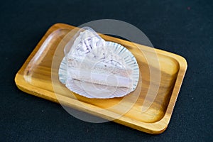 Taro cake on wooden plate with black background